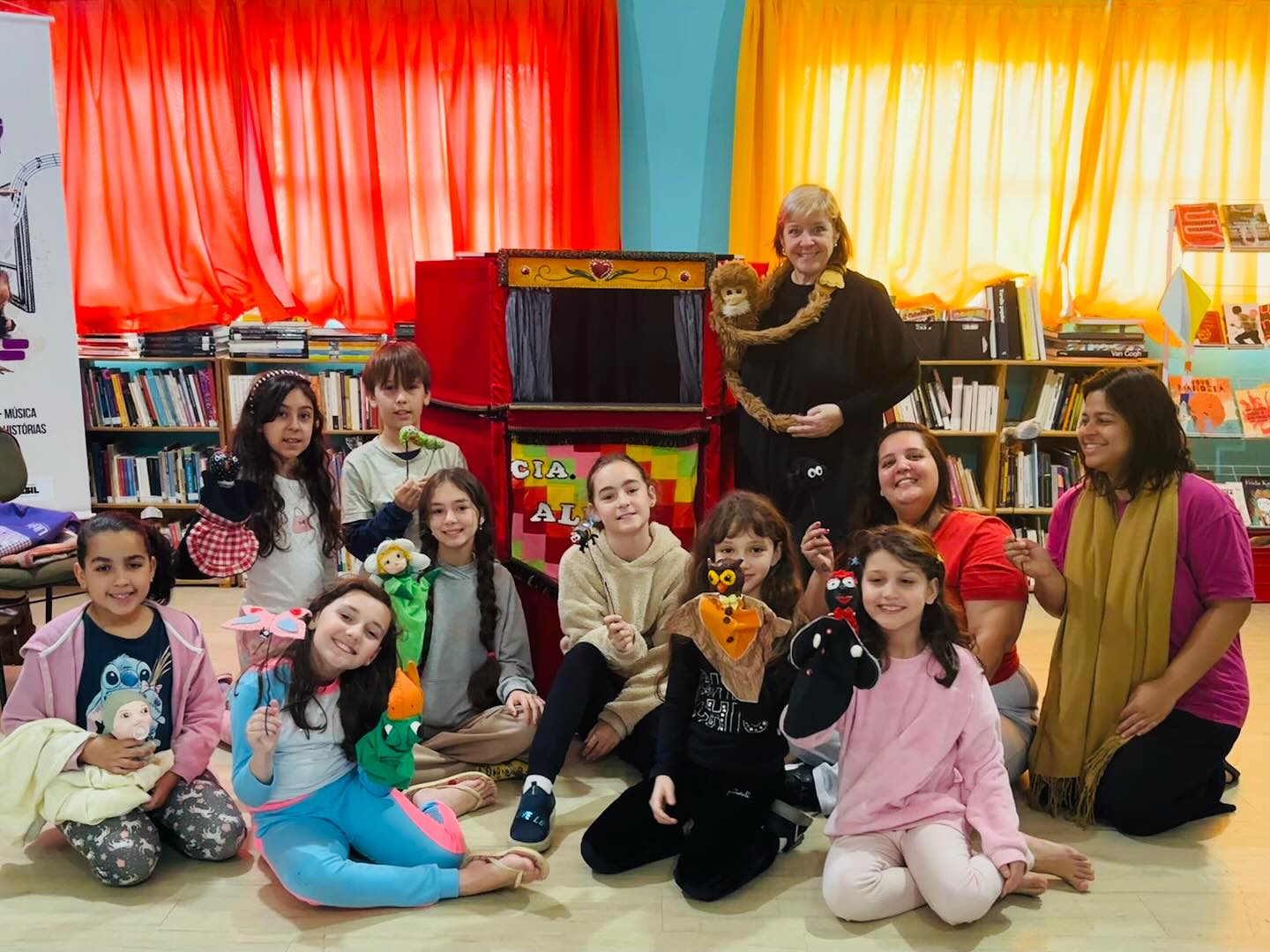 Crianças participando de atividade com fantoches na biblioteca